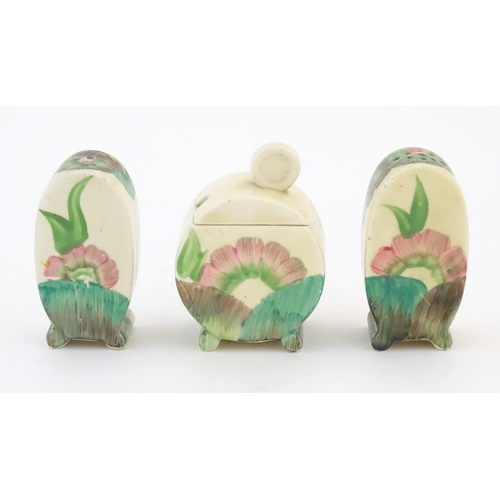 69 - A Clarice Cliff three piece cruet set comprising salt, pepper and mustard pot, with floral decoratio... 