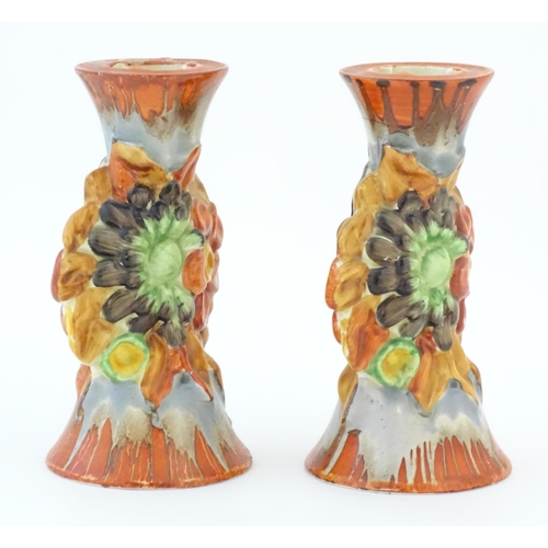 74 - A pair of Clarice Cliff candlesticks in the My Garden pattern, decorated with flowers and foliage. M... 