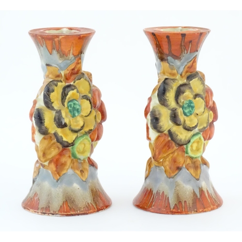 74 - A pair of Clarice Cliff candlesticks in the My Garden pattern, decorated with flowers and foliage. M... 