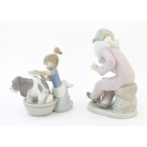 82 - A Lladro model Bashful Bather, no. 5455, depicting a girl washing a dog. Together with a Nao figure ... 