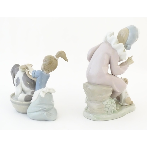 82 - A Lladro model Bashful Bather, no. 5455, depicting a girl washing a dog. Together with a Nao figure ... 