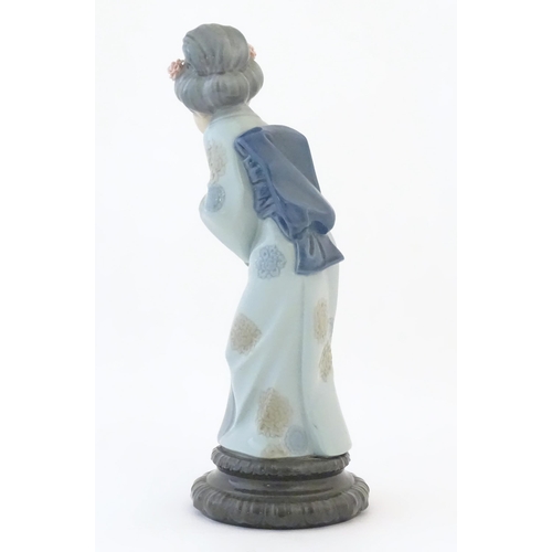 83 - A Lladro model of a Japanese Geisha girl bowing with her hands together, model no. 4989. Marked unde... 