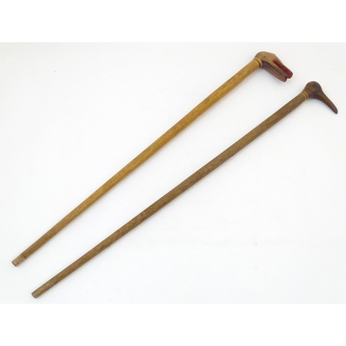 1741 - Two early to mid 20thC palm wood walking sticks, each with carved folkart figural handles, one with ... 