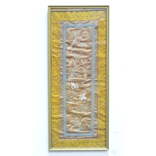 146 - An Oriental embroidery / needlework panel depicting crane birds, trees, fruit and flowers. Approx. 2... 