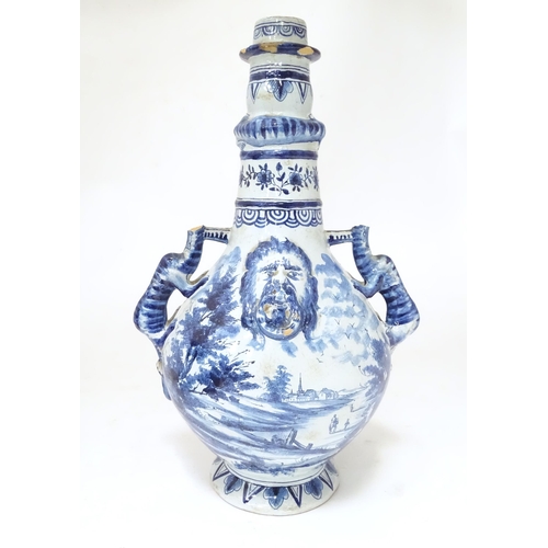 156 - A Continental blue and white bottle vase with twin zoomorphic handles, relief mask detail and relief... 