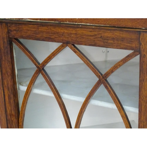 194 - A Victorian hanging oak corner cupboard with a moulded cornice above an astragal glazed door an cont... 