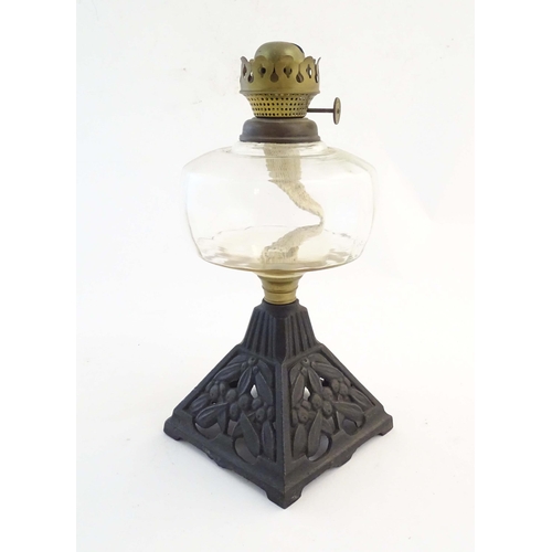 262 - An early 20thC Falk's oil lamp, the clear glass reservoir supported by a cast iron pyramid base with... 