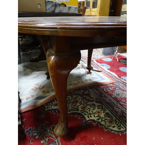 265 - A mahogany oval dining table with cabriole legs and pad feet. Approx 45 3/4