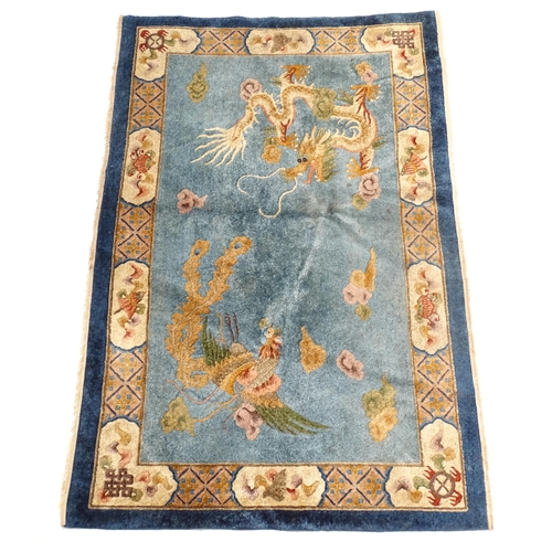 230 - A Chinese rug, the blue ground decorated with dragons, bordered by further dragons and Oriental moti... 