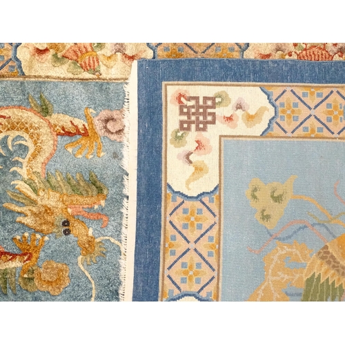 230 - A Chinese rug, the blue ground decorated with dragons, bordered by further dragons and Oriental moti... 