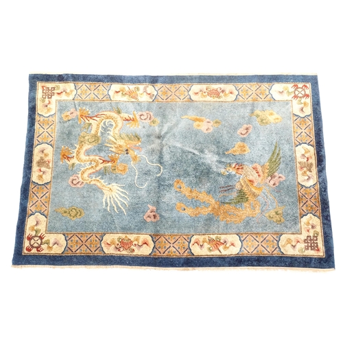 230 - A Chinese rug, the blue ground decorated with dragons, bordered by further dragons and Oriental moti... 