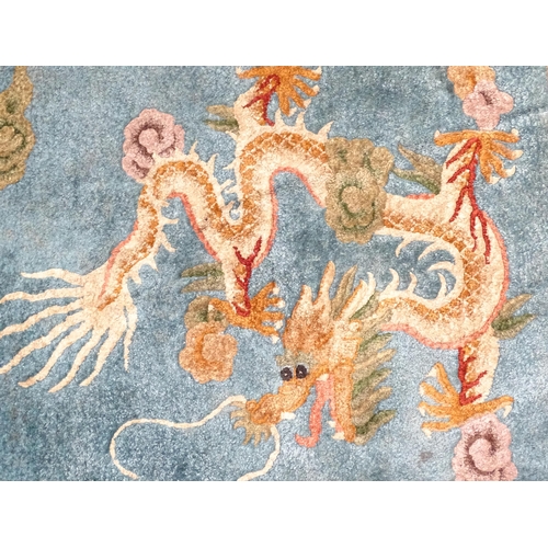 230 - A Chinese rug, the blue ground decorated with dragons, bordered by further dragons and Oriental moti... 