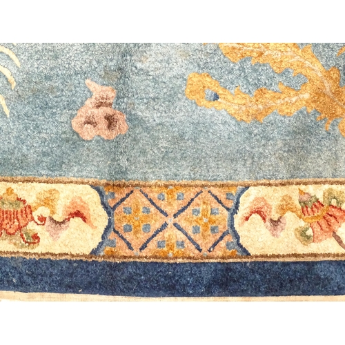 230 - A Chinese rug, the blue ground decorated with dragons, bordered by further dragons and Oriental moti... 