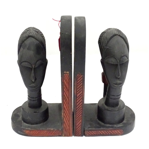 1100 - A pair of African carved hardwood bookends with figural head detail.