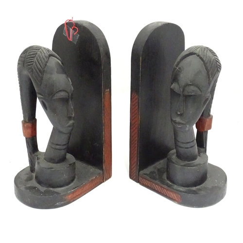 1100 - A pair of African carved hardwood bookends with figural head detail.