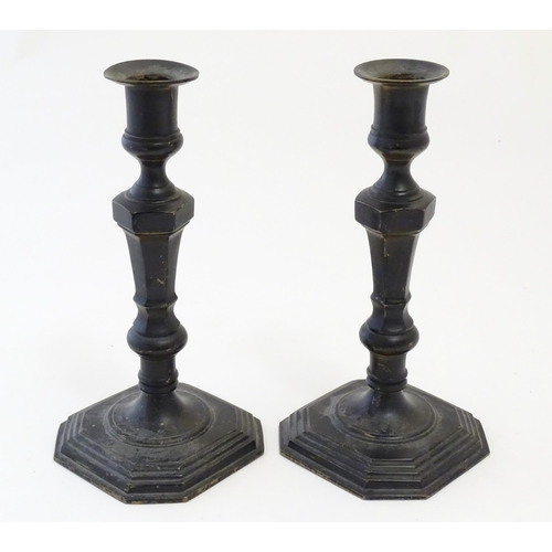 1103 - A pair of 20thC cast candlesticks with double knop faceted stems on a stepped square base with cante... 