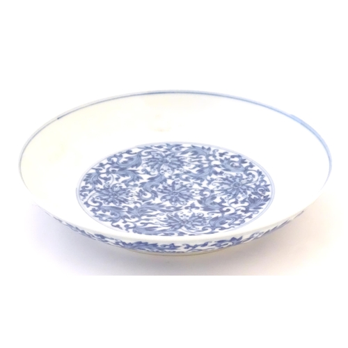 37 - A Chinese blue and white plate decorated with scrolling floral and foliate detail. Character marks u... 