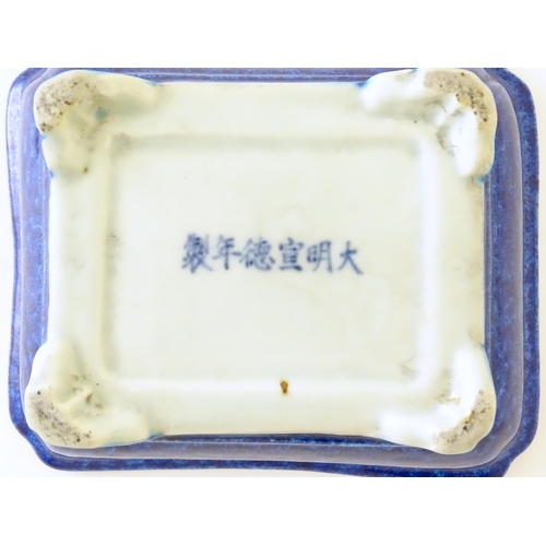 40 - A Chinese dish of rectangular form with a blue glaze, raised on four feet. Character marks under. Ap... 