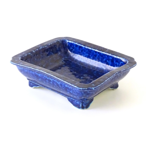 40 - A Chinese dish of rectangular form with a blue glaze, raised on four feet. Character marks under. Ap... 