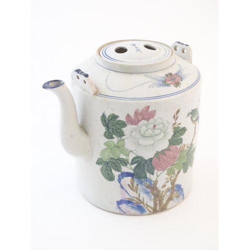 43 - A large Oriental teapot decorated with flowers, foliage and a bird, with scrolling brushwork detail.... 