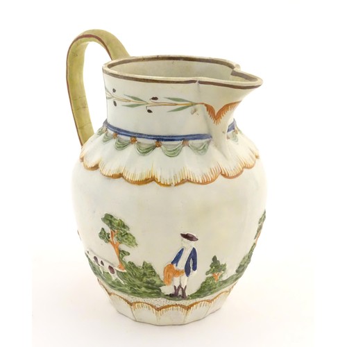 51 - A late 18th / early 19thC jug decorated in Prattware colours depicting a landscape scene with a gent... 