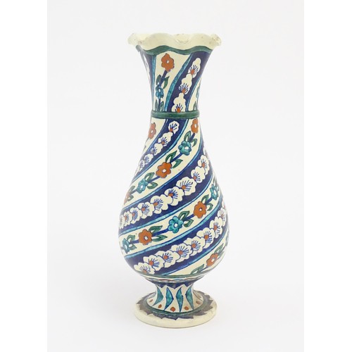 86 - An Iznik style vase with banded blue, white and red floral and foliate detail. Approx. 11 1/2