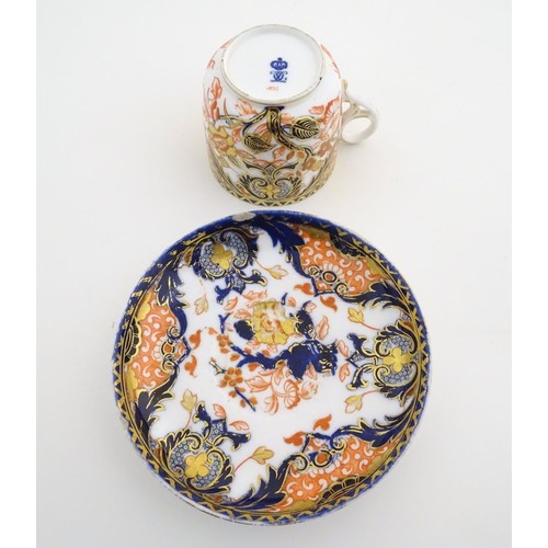 127 - A Royal Crown Derby tea cup and saucer in the Imari palette with floral and scrolling foliate decora... 