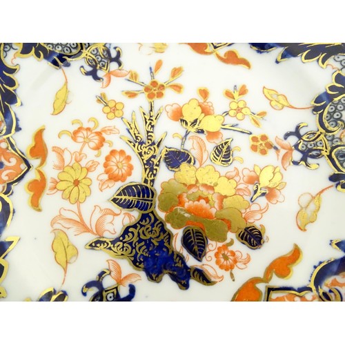 127 - A Royal Crown Derby tea cup and saucer in the Imari palette with floral and scrolling foliate decora... 