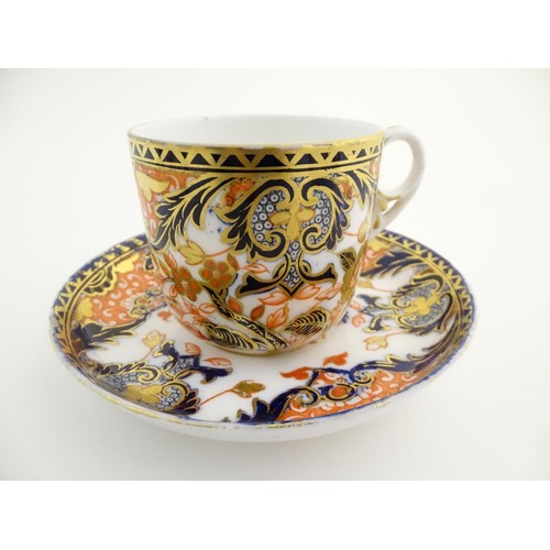 127 - A Royal Crown Derby tea cup and saucer in the Imari palette with floral and scrolling foliate decora... 