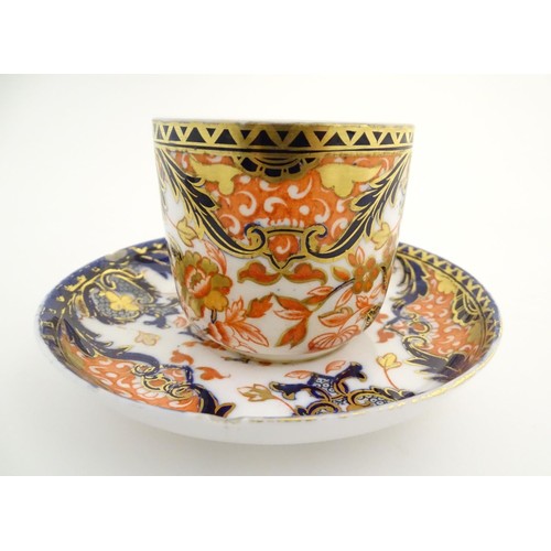 127 - A Royal Crown Derby tea cup and saucer in the Imari palette with floral and scrolling foliate decora... 