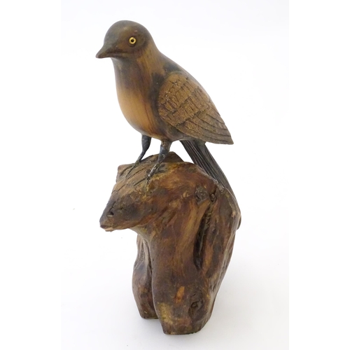 865 - A 20thC carved wooden model of bird on a rocky outcrop. Signed with initials P. N. and dated (19)37 ... 