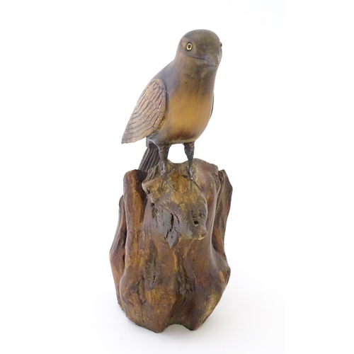 865 - A 20thC carved wooden model of bird on a rocky outcrop. Signed with initials P. N. and dated (19)37 ... 