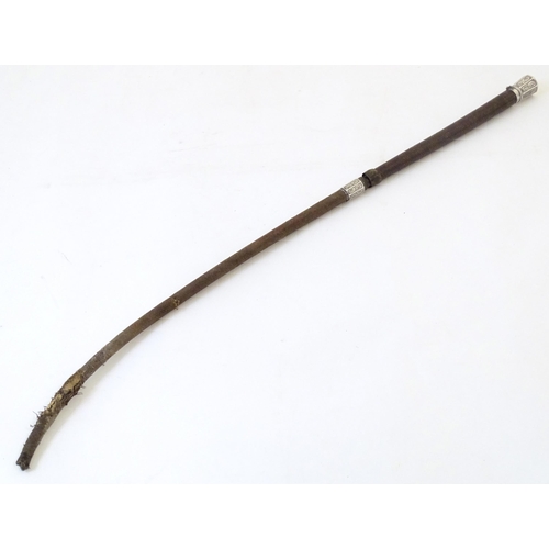 891 - A 19thC riding whip, having woven leather detail with a white metal collar & pommel with C scroll de... 