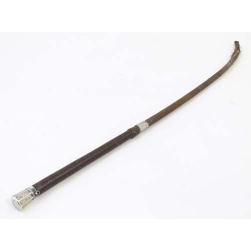 891 - A 19thC riding whip, having woven leather detail with a white metal collar & pommel with C scroll de... 