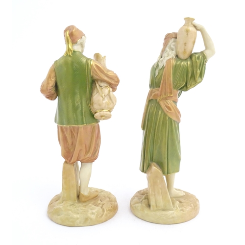 139 - A pair of Royal Worcester blush ivory figures depicting two water carriers holding vases. Marked und... 