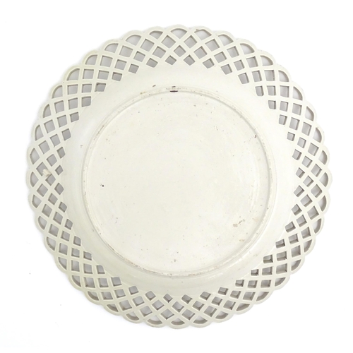 50 - A 19thC creamware plate with basket weave decoration and a reticulated border. Approx. 10 1/4
