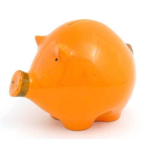 73 - A mid century Italian studio pottery piggy bank modelled as a pig with an orange glaze. Marked Balde... 