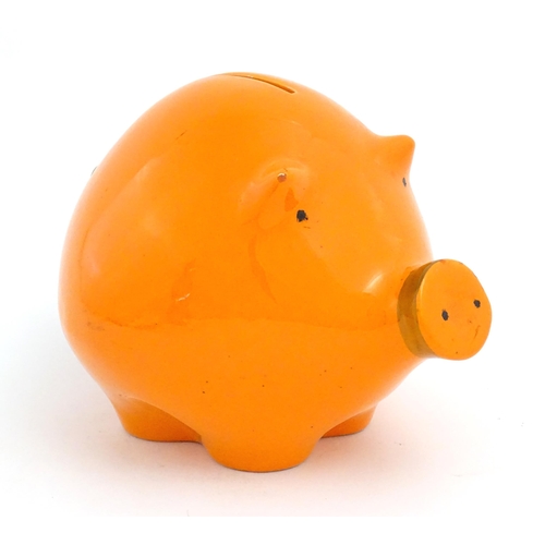 73 - A mid century Italian studio pottery piggy bank modelled as a pig with an orange glaze. Marked Balde... 