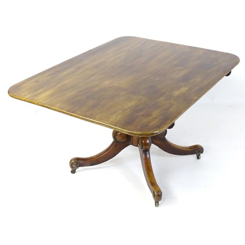 1505 - An early / mid 19thC mahogany tilt top dining table with an oblong top above four legs with applied ... 