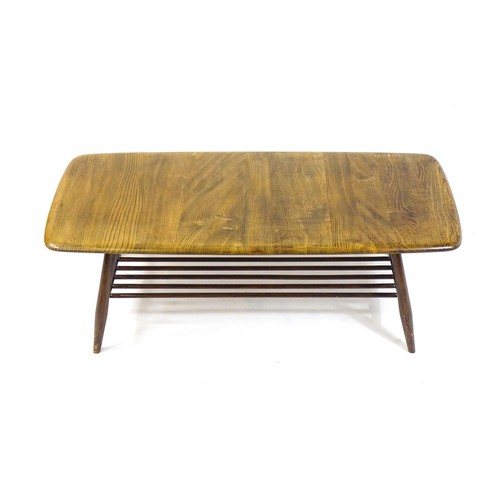 1695 - An elm topped Ercol coffee table with four turned tapering splayed legs united by a turned undertier... 
