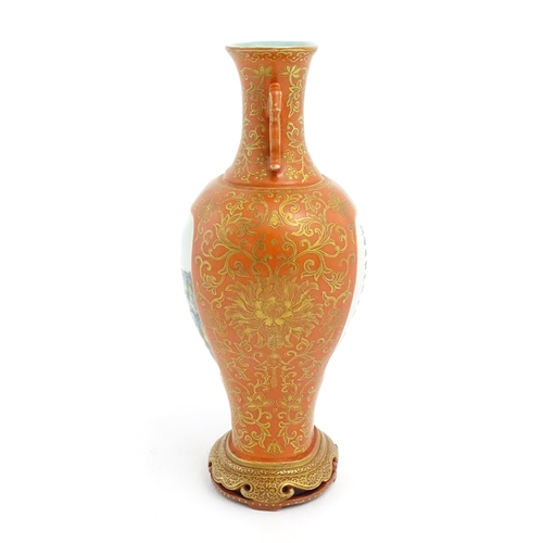 7 - A Chinese vase with a burnt orange ground decorated with gilt floral, foliate and bat detail, and tw... 