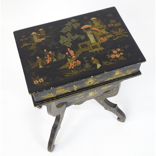 1504 - A 19thC oriental style work table, having an ebonised finish and painted chinoiserie decoration, hav... 