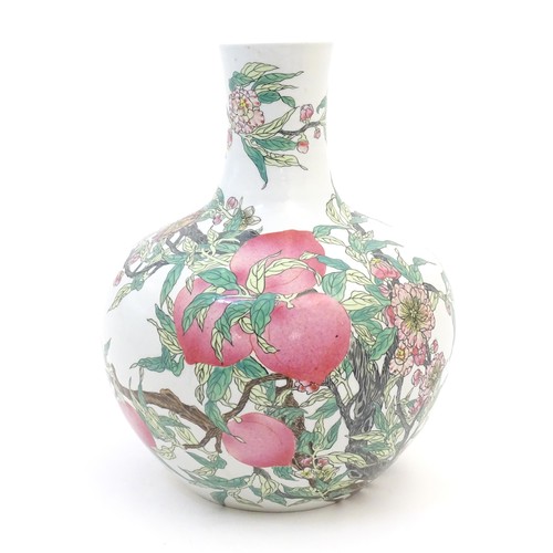 32 - A Chinese famille rose bottle vase decorated in the nine peaches pattern with a fruiting tree with f... 