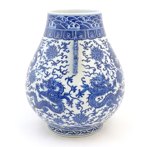 10 - A Chinese blue and white Hu vase with scrolled twin handles, the body decorated with dragons and peo... 