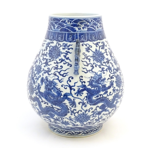 10 - A Chinese blue and white Hu vase with scrolled twin handles, the body decorated with dragons and peo... 