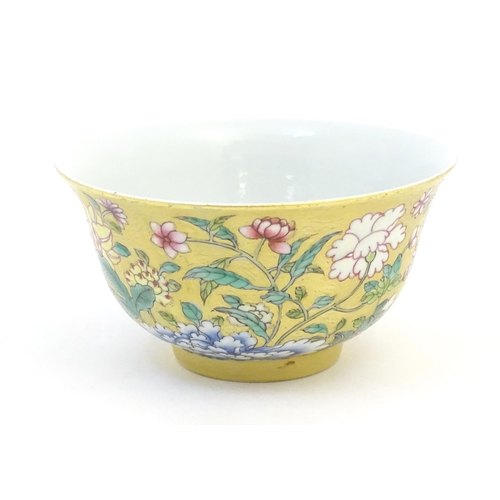 11 - A Chinese famille rose small bowl with a gilt ground decorated with flowers and foliage. Character m... 