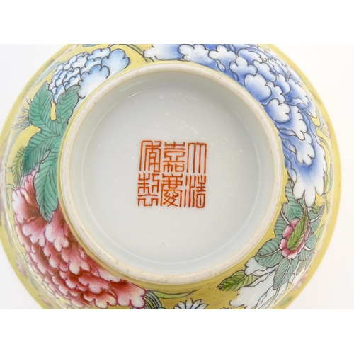 11 - A Chinese famille rose small bowl with a gilt ground decorated with flowers and foliage. Character m... 