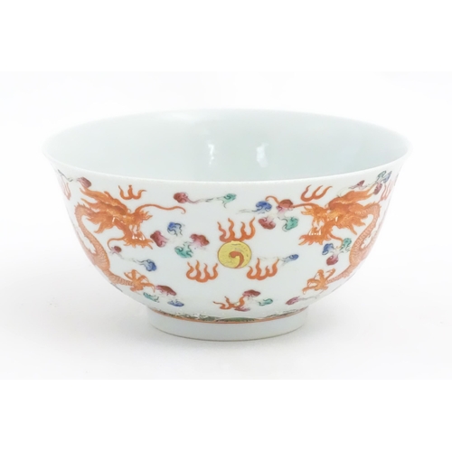 14 - A Chinese famille rose bowl decorated with two dragons and a flaming pearl. Character marks under. A... 