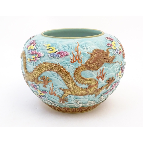 16 - A Chinese vase / pot decorated in relief with dragons, flaming pearl, stylised clouds and waves. Cha... 