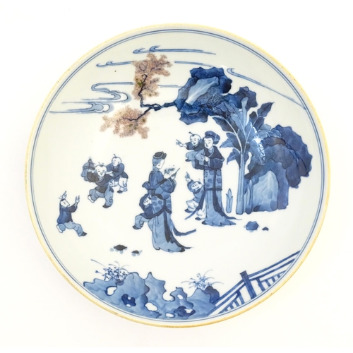 17 - A Chinese blue and white dish decorated with figures in a garden landscape. Character marks under. A... 